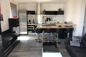 kuchnia z blatem i bar z stołkami w obiekcie Appartement vue panoramique sur la mer et la citadelle de Bastia w Bastii