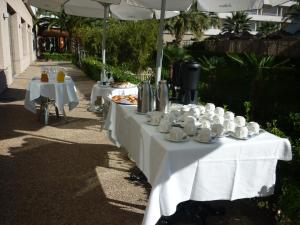 a couple of tables with cups and plates of food at AGH Canet in Canet de Berenguer