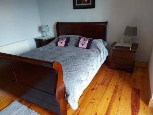 1 dormitorio con 1 cama de madera y 2 mesitas de noche en Minaun Cliff View en Achill