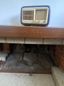 una vieja radio sentada sobre una mesa de madera en Maura's Retreat en Montepulciano Stazione