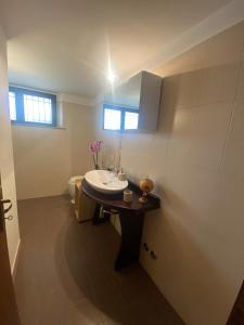 een badkamer met een witte wastafel en een spiegel bij Maura's Retreat in Montepulciano Stazione