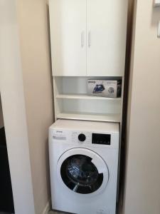 een wasmachine en droger in een kleine kamer bij В сърцето на Варна ви очаква прекрасен и просторен апартамент in Varna