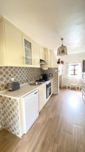 a kitchen with white cabinets and a wooden floor at Celestial Melides Country House in Melides