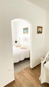 - une chambre blanche avec un lit et un miroir dans l'établissement Celestial Melides Country House, à Melides