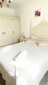 a white bed with two pillows on it in a room at Celestial Melides Country House in Melides