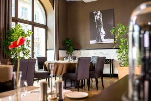 a restaurant with a table and chairs and a window at Astoria Hotel in Lviv