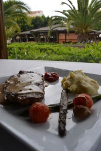 a plate of food with meat and vegetables on a table at AGH Canet in Canet de Berenguer