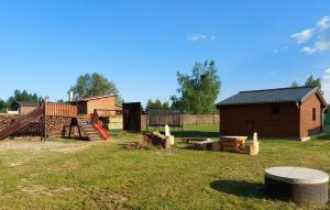 patio con parque infantil y casa de madera en Chatička Evička, en Suchý