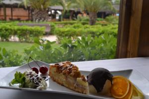 a plate of food with a piece of cake and fruit at AGH Canet in Canet de Berenguer