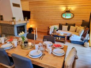 uma sala de jantar com uma mesa e um sofá em Złoty Dom Brenna em Brenna