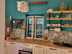 a kitchen with a counter and a blue wall at House Grabic in Tivat