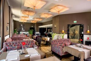 a restaurant with couches and tables and chairs at Astoria Hotel in Lviv