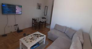 uma sala de estar com um sofá e uma mesa em Apartment Luka em Podgorica
