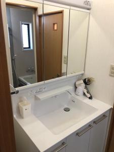uma casa de banho com um lavatório e um espelho grande em Hummingbird Kanazawa em Kanazawa