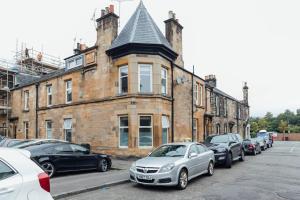 a row of cars parked in front of a brick building at Stylish Stirling Apartment - free parking in Stirling