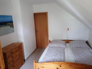 - une chambre avec 2 lits et une armoire en bois dans l'établissement Reiterhof Groß Stubben, à Poseritz
