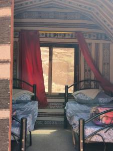 a room with two beds and a window at Bedouin Family Camp in Wadi Rum