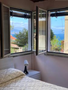 a bedroom with two windows and a bed with a lamp at Terra mia in Naples +17 photos