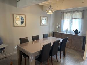 une salle à manger avec une table et des chaises dans l'établissement Gites des marronniers proche du Tréport, à Saint-Martin-le-Gaillard