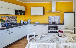 una cucina con armadi bianchi e un tavolo con un computer portatile di Beautiful Home In Rukieten With Wifi a Rukieten