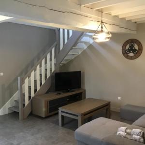 ein Wohnzimmer mit einer Treppe und einem TV in der Unterkunft Gites des marronniers proche du Tréport in Saint-Martin-le-Gaillard