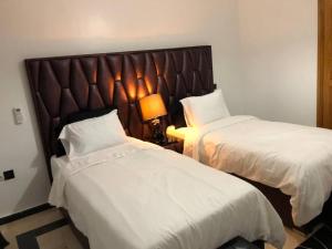 马拉喀什Beautiful Luxury 2 bedrooms Apartment in Marrakech的一间有两张床和一盏灯的酒店房间 更多41张照片