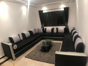 马拉喀什Beautiful Luxury 2 bedrooms Apartment in Marrakech的客厅里有一张黑色沙发和一台电视