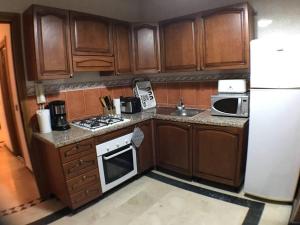 马拉喀什Beautiful Luxury 2 bedrooms Apartment in Marrakech的配有木质橱柜和白色冰箱的厨房