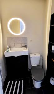 ein Badezimmer mit einem WC, einem Waschbecken und einem Spiegel in der Unterkunft Handy Studio near Nato in Brüssel