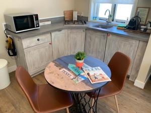 a kitchen with a table and chairs with books on it at B&B Beach House Texel in De Koog
