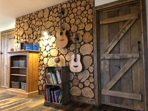 um quarto com duas guitarras penduradas numa parede em Deer Den timber clad cabin with hot tub, up private lane em Cullompton