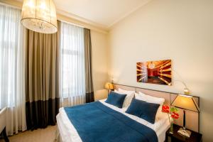a hotel room with a bed with blue pillows at Astoria Hotel in Lviv