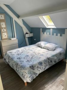 une chambre avec un lit avec un mur bleu dans l'établissement Gites des marronniers proche du Tréport, à Saint-Martin-le-Gaillard