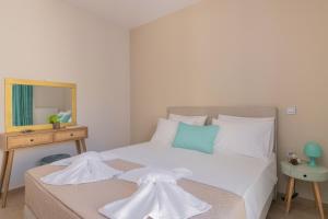 a bedroom with a large white bed with a mirror at Emyria-Two-Floor Apartment with roof terrace in Zakynthos Town