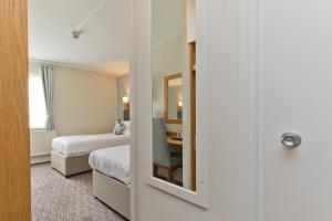 Un pat sau paturi într-o cameră la Blue Bell Lodge Hotel