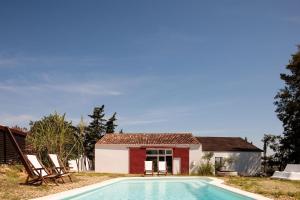 a villa with a swimming pool in front of a house at Companhia das Culturas - Ecodesign & Spa Hotel in Castro Marim