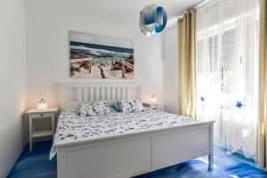 a bedroom with a white bed with a blue floor at Apartment Dora in Umag