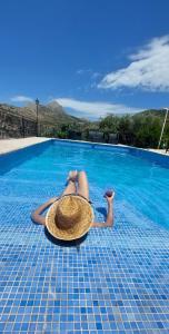 una mujer con un sombrero de paja tendida en una piscina en Casa Jabero, en Nívar