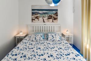 a bedroom with a bed with a blue and white bedspread at Apartment Dora in Umag
