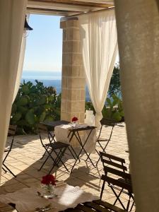 una mesa y sillas en un patio con vistas al océano en Dimora Le Ginestre, en Fasano