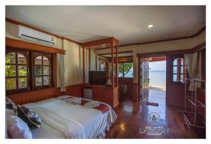 een slaapkamer met een bed en een televisie. bij Koh Chang Lagoon Princess in Ko Chang