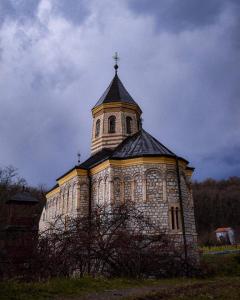 um edifício com uma cruz no topo em Petlov Konak em Mala Remeta