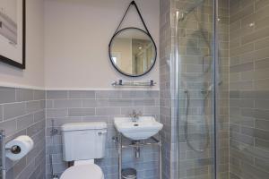 bagno con servizi igienici, lavandino e specchio di Sentry Mead Hotel a Totland