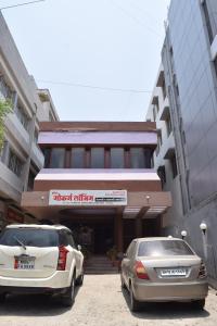 two cars parked in front of a building at Hotel Gokarn Lodging in Satara