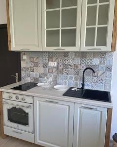 a kitchen with white cabinets and a sink at Joanna’s home in Veliko Tŭrnovo