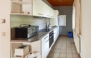 a small kitchen with white cabinets and a microwave at Ferienhaus 16 In Thalfang in Thalfang