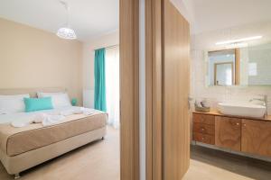 een slaapkamer met een bed en een badkamer met een wastafel bij Emyria-Two-Floor Apartment with roof terrace in Zakynthos