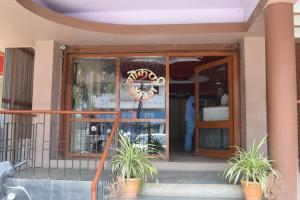 an open door of a building with potted plants outside at Hotel Gokarn Lodging in Satara