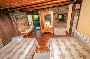 a room with two beds and a stone wall at Casa Do Concello in Arnado