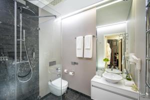 a bathroom with a toilet and a sink and a shower at Astoria Hotel in Lviv